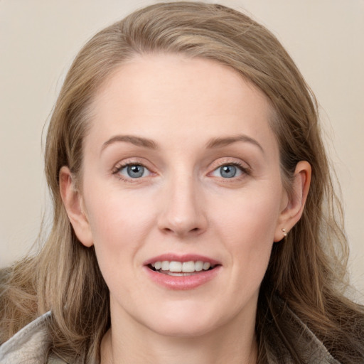 Joyful white young-adult female with long  brown hair and blue eyes