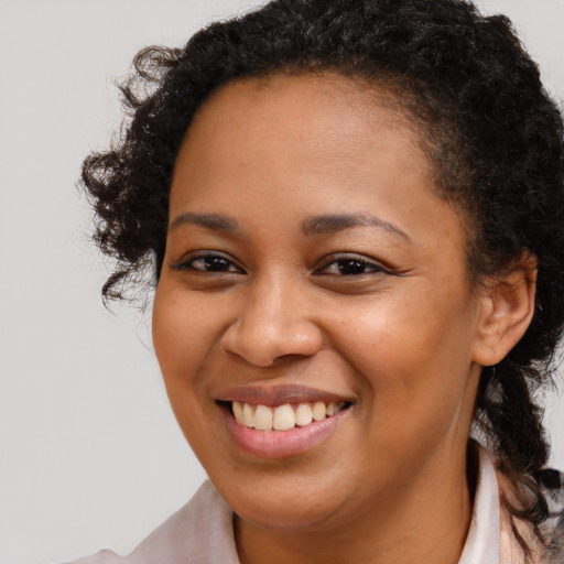 Joyful black young-adult female with medium  brown hair and brown eyes