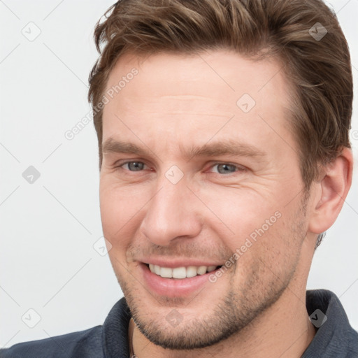 Joyful white young-adult male with short  brown hair and grey eyes