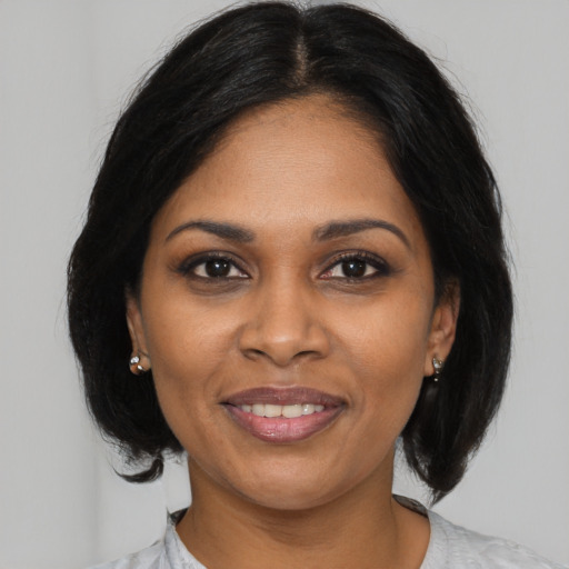 Joyful black young-adult female with medium  black hair and brown eyes