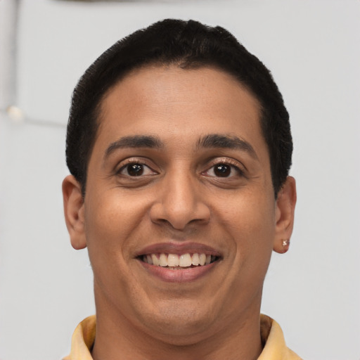 Joyful latino young-adult male with short  brown hair and brown eyes