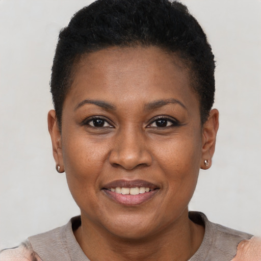 Joyful black adult female with short  brown hair and brown eyes