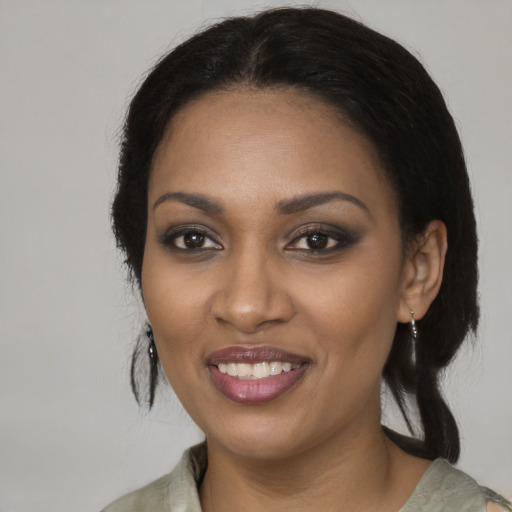 Joyful black young-adult female with long  brown hair and brown eyes