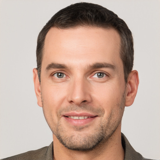 Joyful white young-adult male with short  brown hair and grey eyes