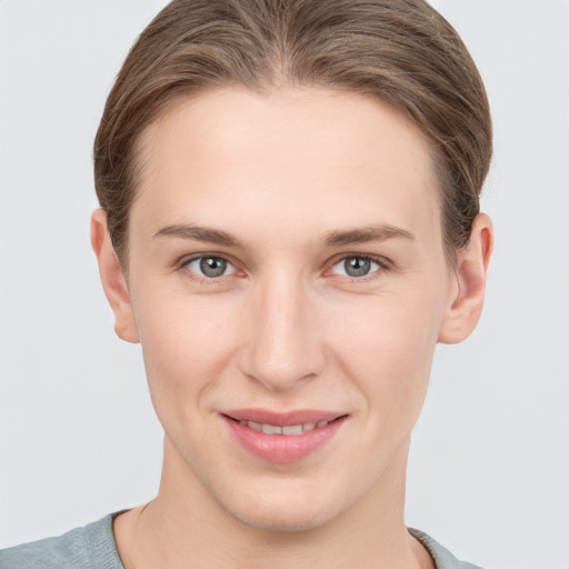 Joyful white young-adult female with short  brown hair and grey eyes