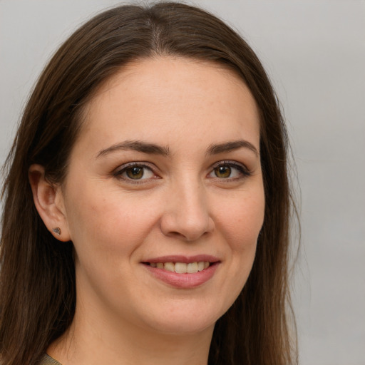 Joyful white young-adult female with long  brown hair and green eyes