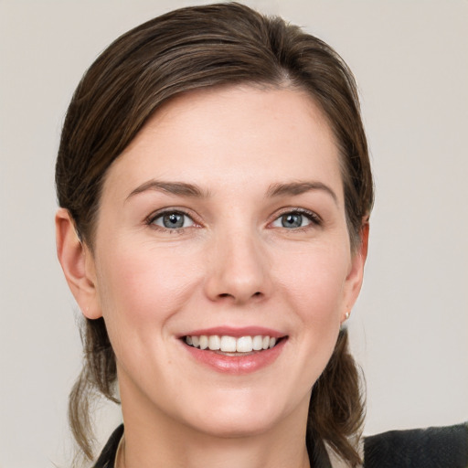 Joyful white young-adult female with medium  brown hair and grey eyes