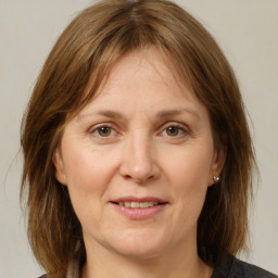 Joyful white adult female with medium  brown hair and grey eyes