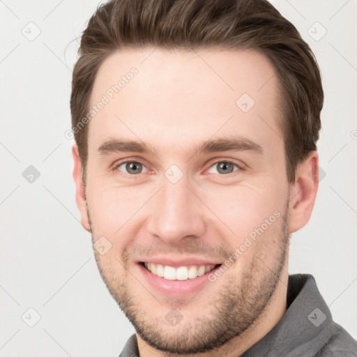 Joyful white young-adult male with short  brown hair and grey eyes