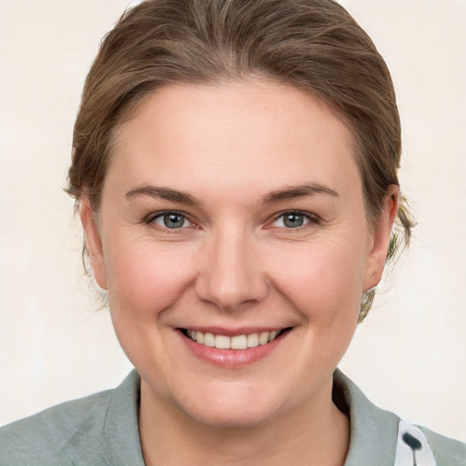 Joyful white young-adult female with medium  brown hair and grey eyes