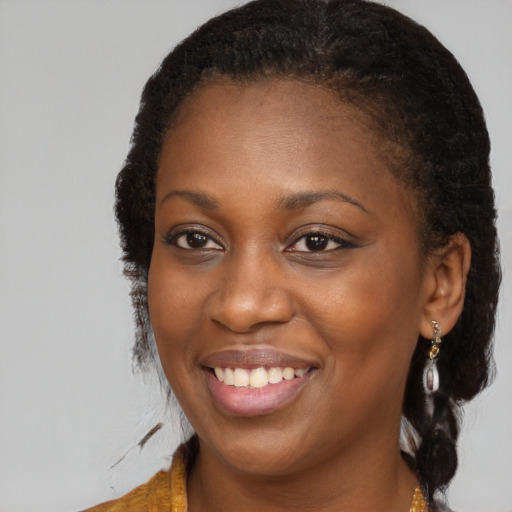 Joyful black young-adult female with long  brown hair and brown eyes