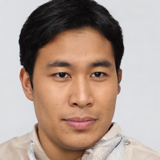 Joyful asian young-adult male with short  brown hair and brown eyes