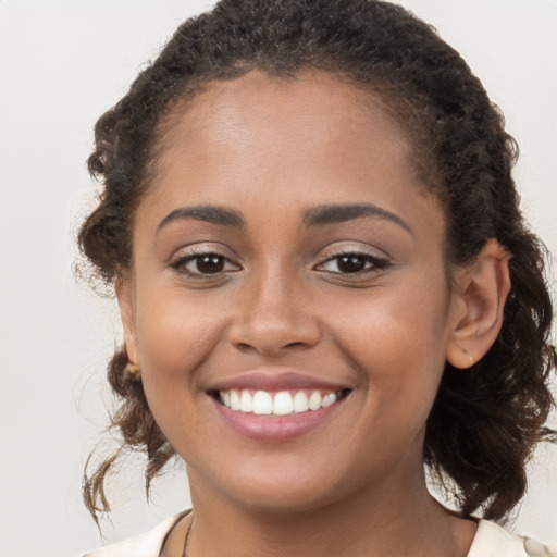 Joyful latino young-adult female with long  brown hair and brown eyes