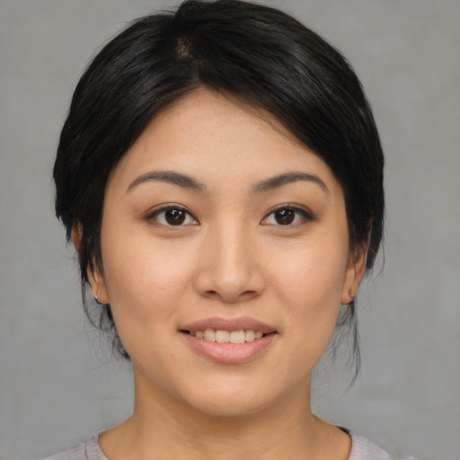 Joyful asian young-adult female with medium  black hair and brown eyes