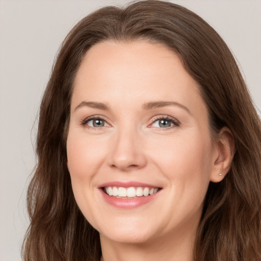 Joyful white young-adult female with long  brown hair and grey eyes