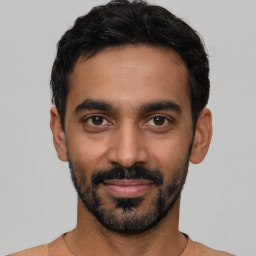 Joyful latino young-adult male with short  black hair and brown eyes