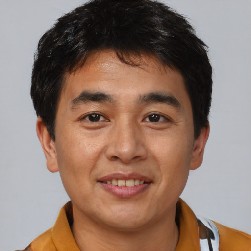 Joyful asian young-adult male with short  brown hair and brown eyes