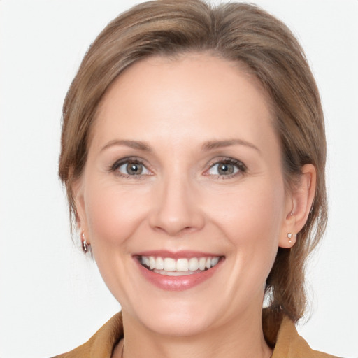 Joyful white adult female with medium  brown hair and grey eyes