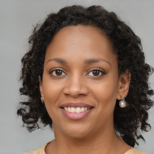 Joyful black young-adult female with medium  brown hair and brown eyes