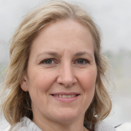 Joyful white adult female with medium  brown hair and blue eyes