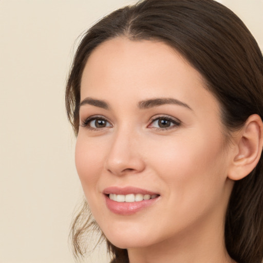 Joyful white young-adult female with long  brown hair and brown eyes