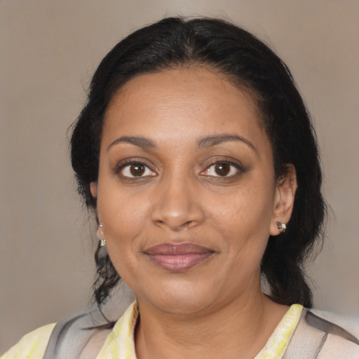 Joyful black adult female with medium  brown hair and brown eyes