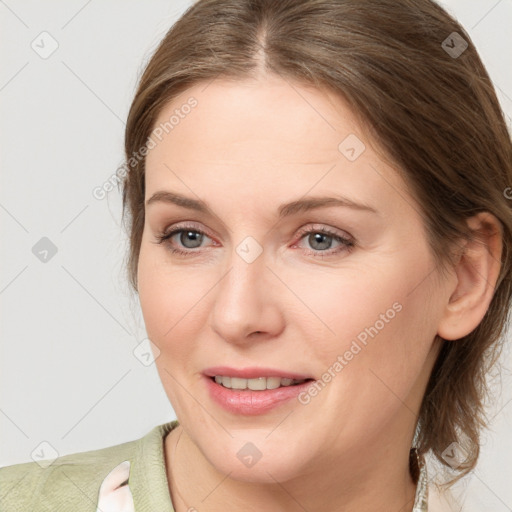 Joyful white young-adult female with medium  brown hair and grey eyes