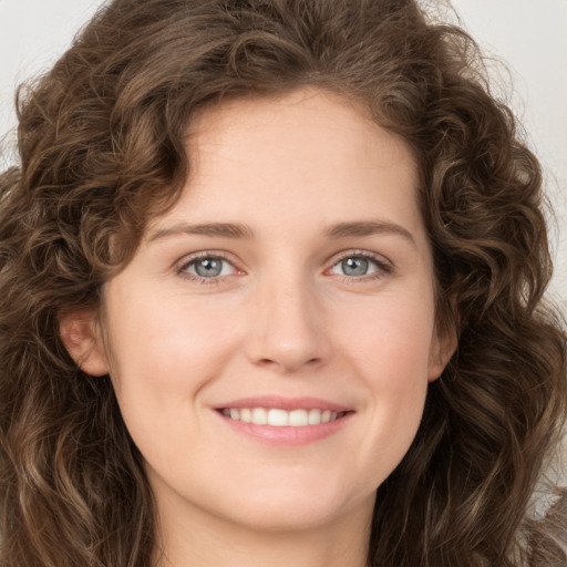 Joyful white young-adult female with long  brown hair and green eyes