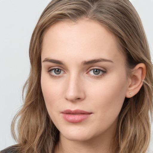 Joyful white young-adult female with long  brown hair and blue eyes