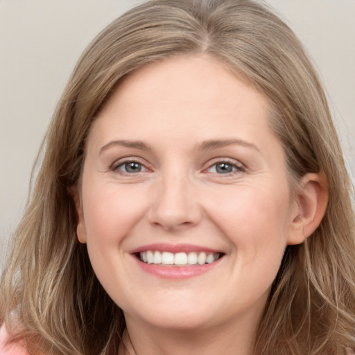 Joyful white young-adult female with long  brown hair and grey eyes