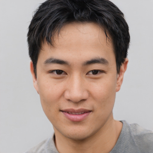 Joyful asian young-adult male with short  brown hair and brown eyes