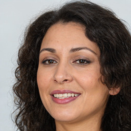 Joyful white adult female with long  brown hair and brown eyes