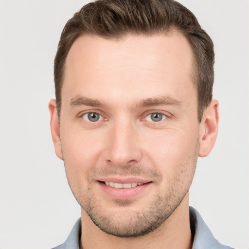 Joyful white young-adult male with short  brown hair and grey eyes