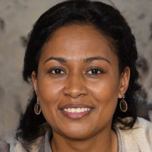 Joyful latino adult female with medium  brown hair and brown eyes