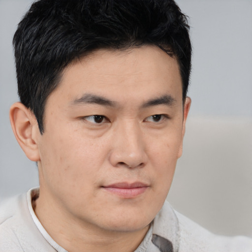 Joyful asian young-adult male with short  brown hair and brown eyes