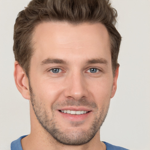 Joyful white young-adult male with short  brown hair and grey eyes