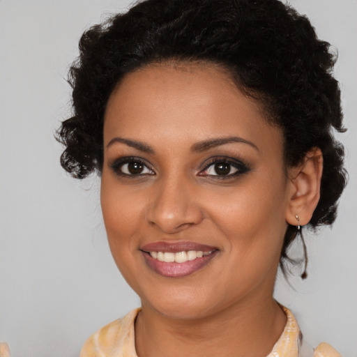 Joyful black young-adult female with medium  brown hair and brown eyes
