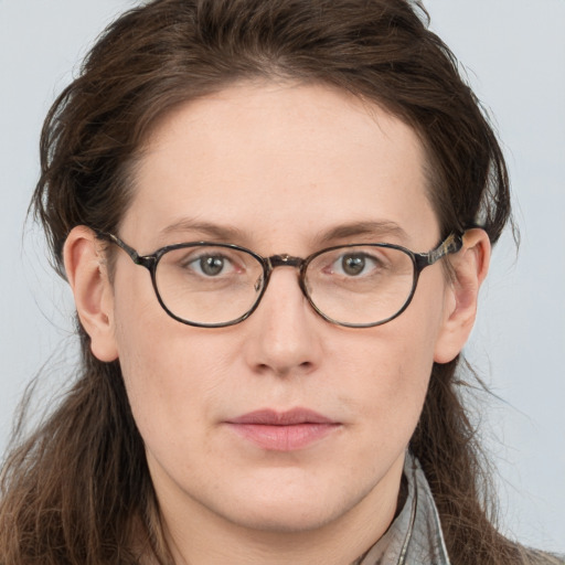 Joyful white young-adult female with long  brown hair and blue eyes