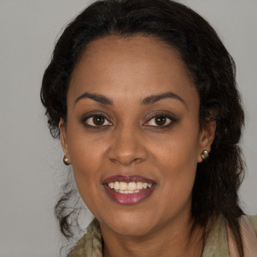 Joyful black young-adult female with long  brown hair and brown eyes
