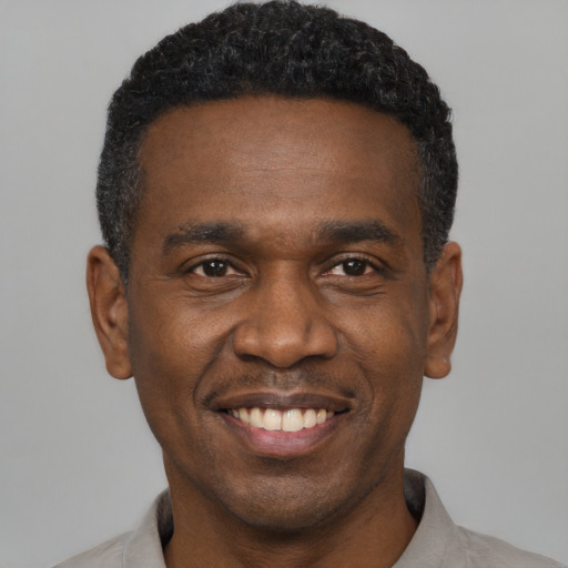 Joyful black young-adult male with short  black hair and brown eyes