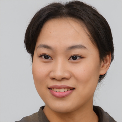 Joyful asian young-adult female with short  brown hair and brown eyes