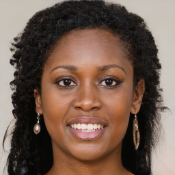 Joyful black young-adult female with long  brown hair and brown eyes