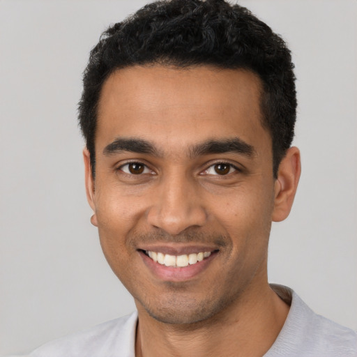 Joyful latino young-adult male with short  black hair and brown eyes