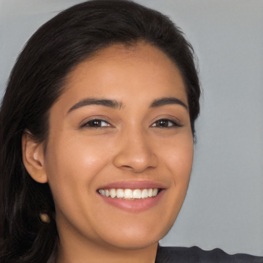 Joyful latino young-adult female with long  brown hair and brown eyes