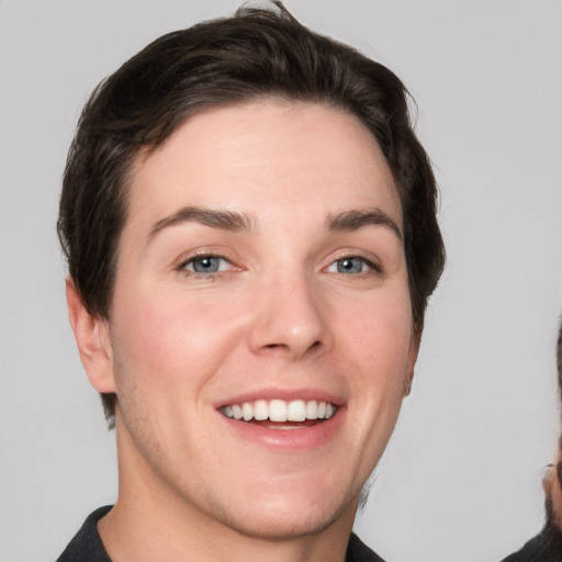 Joyful white young-adult female with short  brown hair and grey eyes