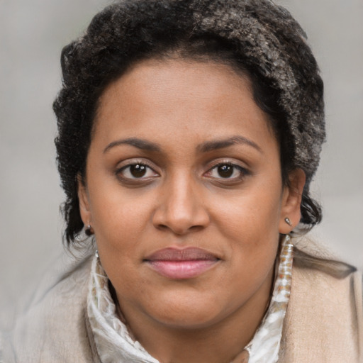 Joyful black young-adult female with short  brown hair and brown eyes