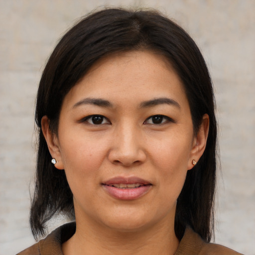 Joyful latino adult female with medium  brown hair and brown eyes