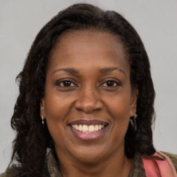 Joyful black adult female with long  brown hair and brown eyes