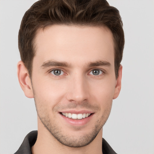 Joyful white young-adult male with short  brown hair and grey eyes