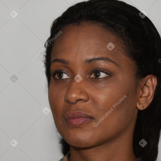 Joyful black young-adult female with long  black hair and brown eyes